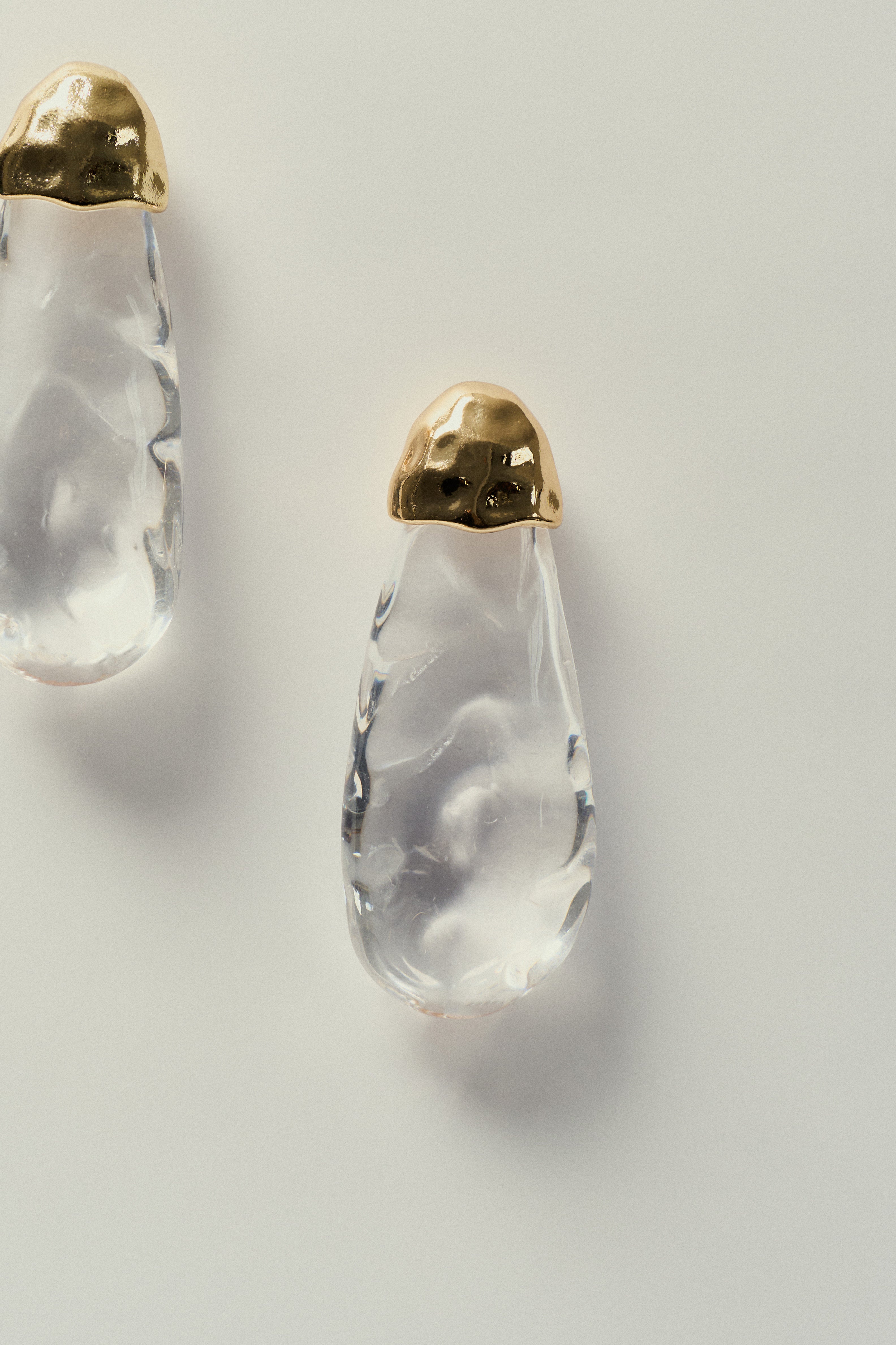 Brinco_Gota_Organico_em_Resina_Translucida_Detalhe_Dourado.jpg