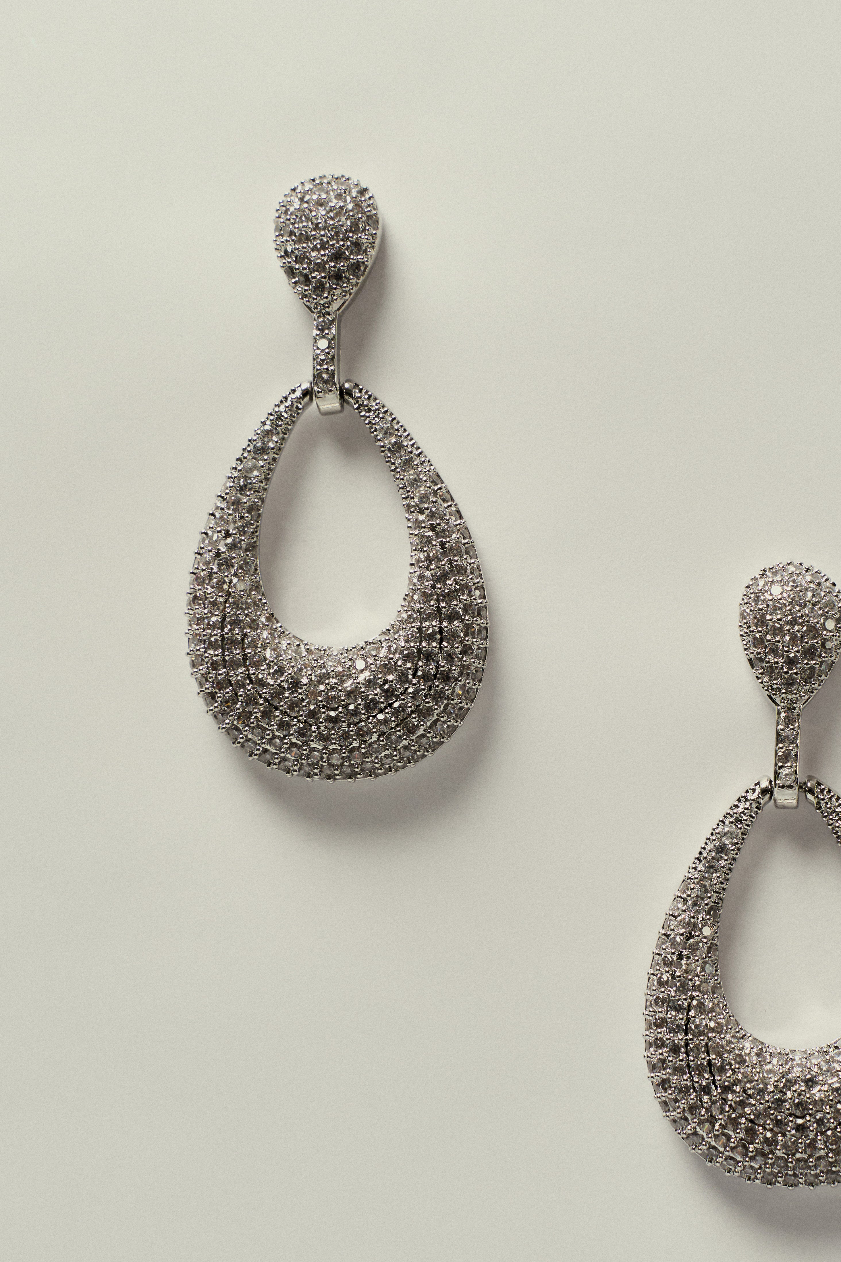 Brinco_Oval_Vazado_Cravejado_de_Strass_Prateado1.jpg