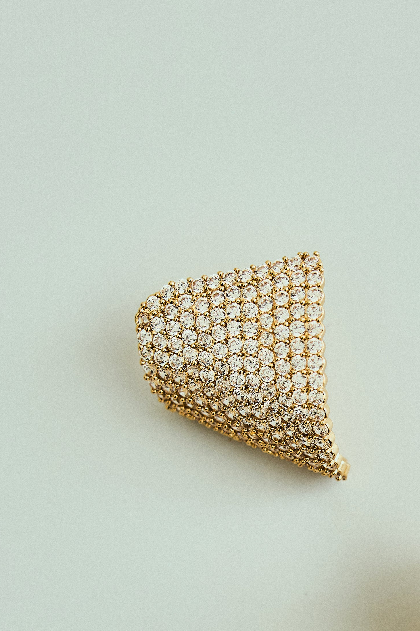Brinco Curvado Cravejado com Strass Dourado