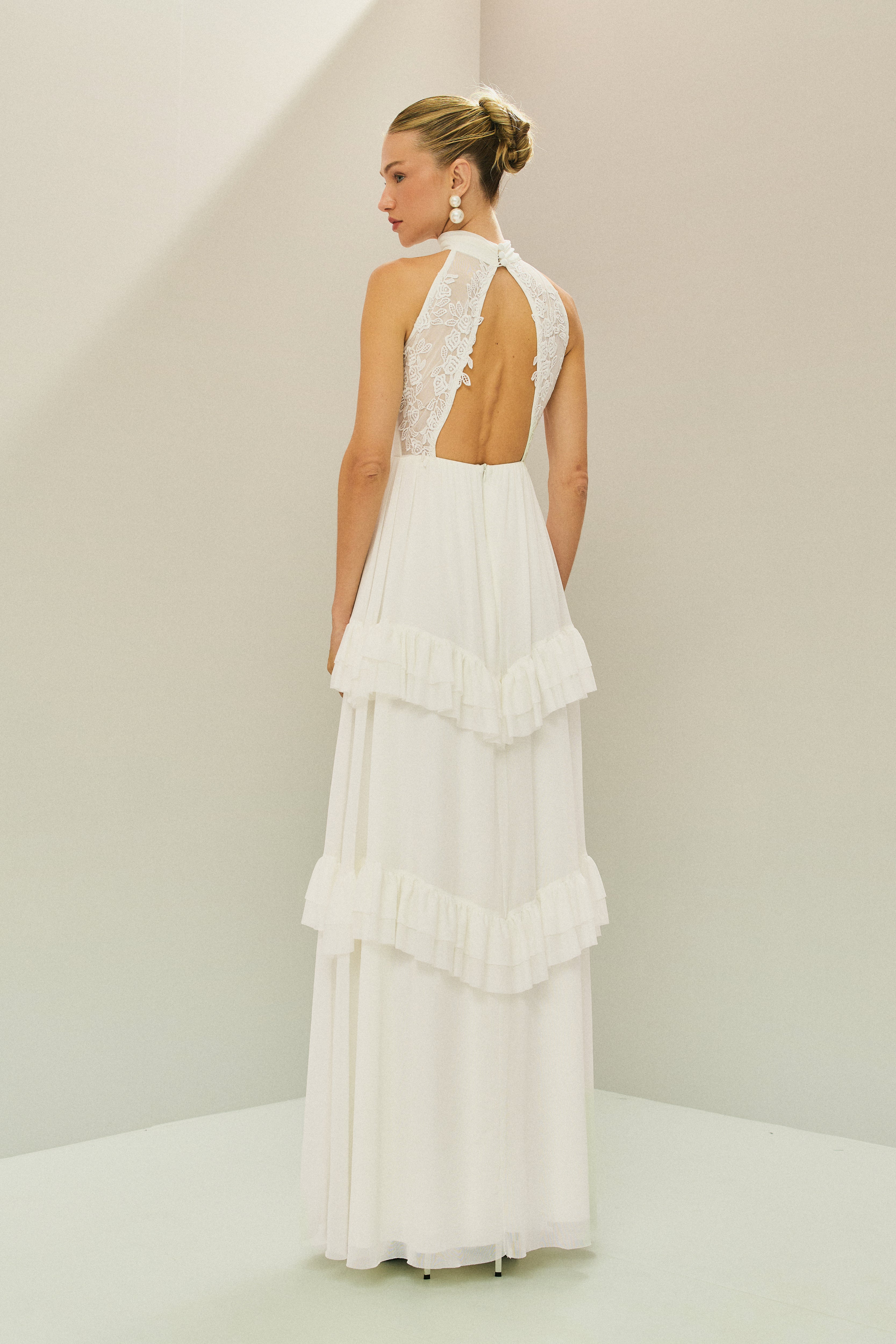 Vestido Longo em Tule com Gola Alta, Costas Abertas com Aplicação de Renda Guipir e Saia em Camadas com Babados - Mons Off White